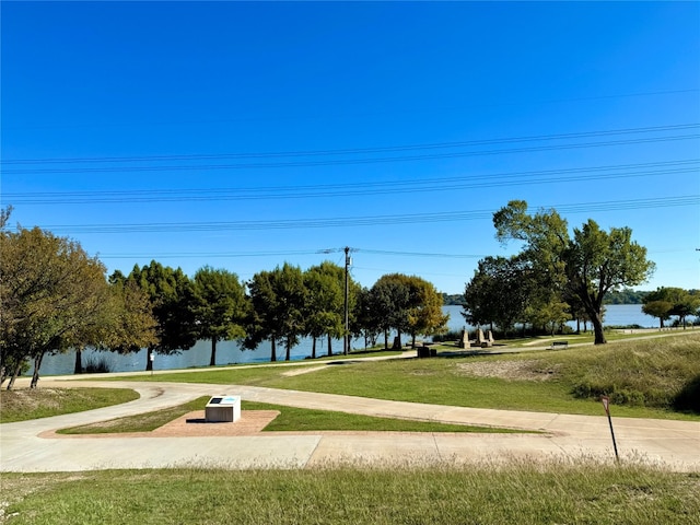 surrounding community with a yard and a water view