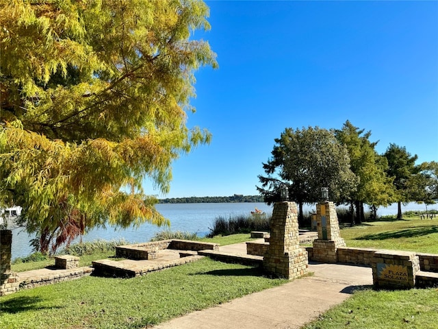 view of home's community featuring a lawn and a water view