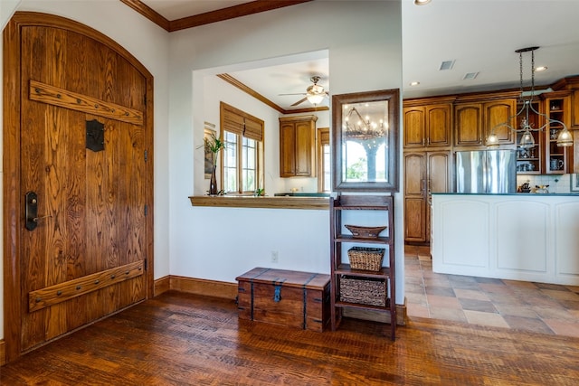 kitchen featuring crown molding, ceiling fan, stainless steel fridge, decorative light fixtures, and dark hardwood / wood-style flooring