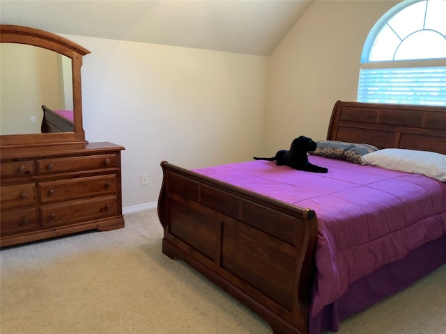 bedroom with light colored carpet and vaulted ceiling