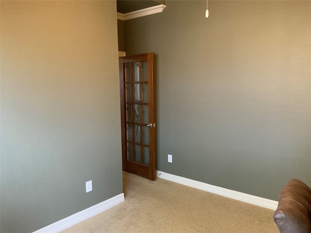 spare room with ornamental molding and light colored carpet