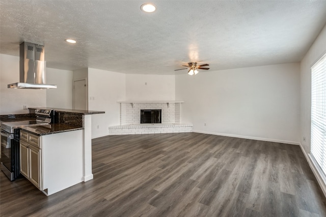 kitchen featuring stainless steel electric range oven, dark stone counters, island exhaust hood, and dark hardwood / wood-style floors