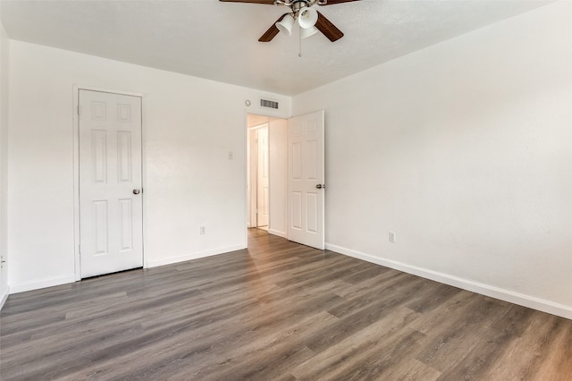 empty room with ceiling fan and dark wood-type flooring