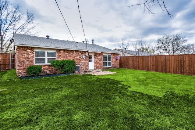 rear view of property featuring a yard and a patio