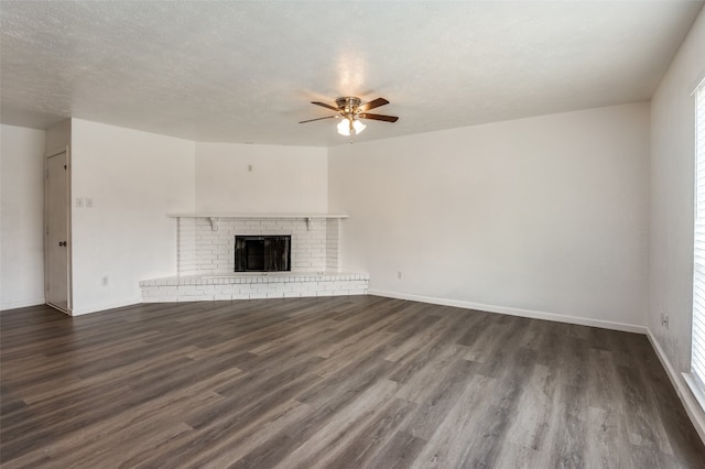 unfurnished living room featuring ceiling fan, dark wood-type flooring, a textured ceiling, and a fireplace