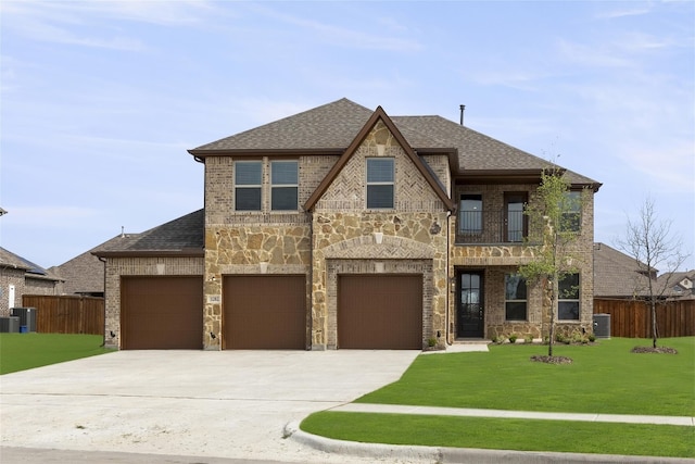 view of front of property with a garage, central air condition unit, a balcony, and a front yard