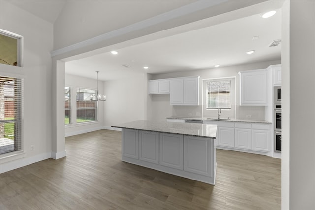 kitchen with plenty of natural light, pendant lighting, and white cabinetry