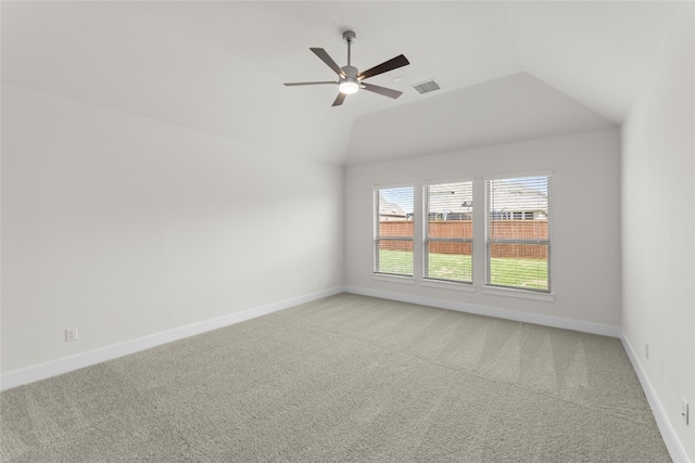 spare room featuring ceiling fan, vaulted ceiling, and light carpet