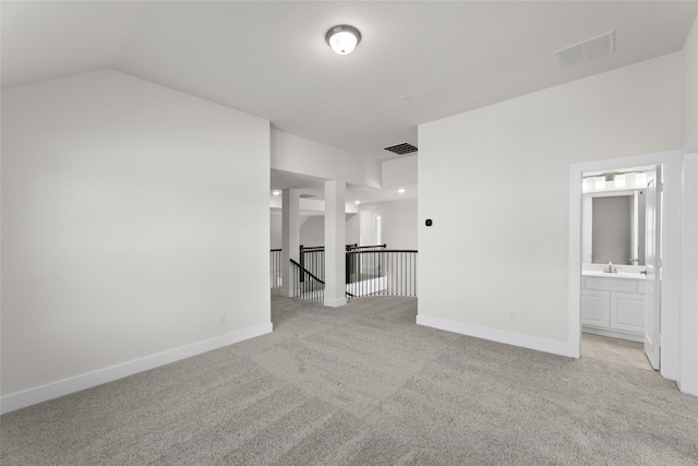 carpeted empty room with lofted ceiling and sink