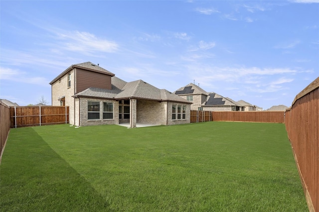 back of house featuring a patio area and a lawn