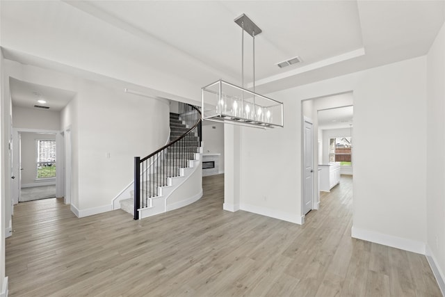 interior space featuring light wood-type flooring and a tray ceiling