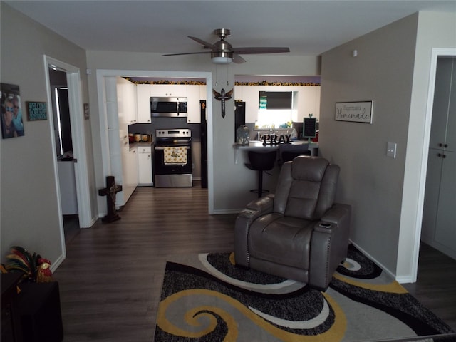 living room featuring dark hardwood / wood-style floors and ceiling fan