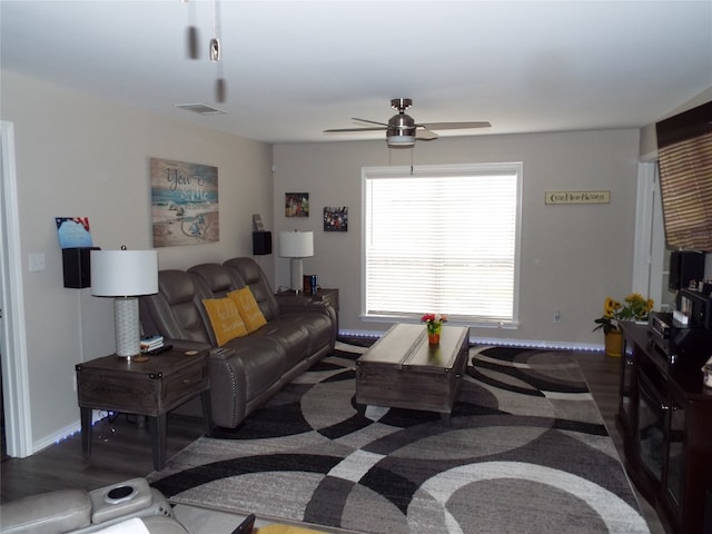 living room featuring ceiling fan and dark wood-type flooring