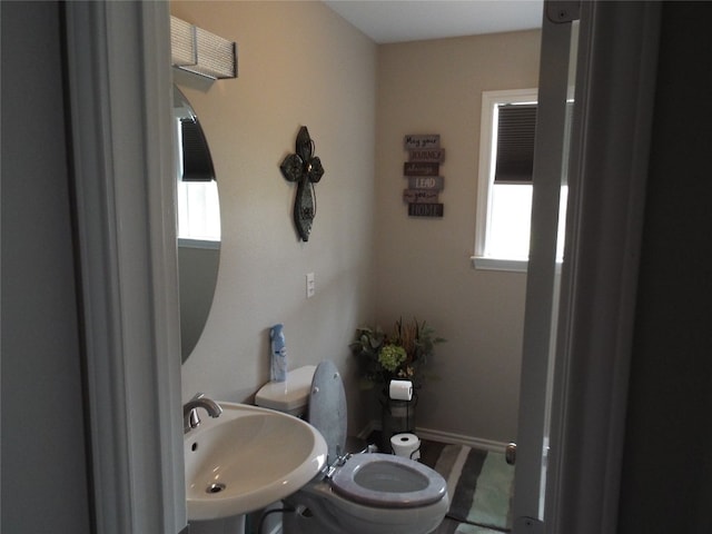 bathroom with plenty of natural light, toilet, and sink