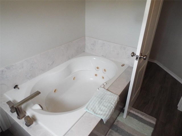 bathroom with wood-type flooring and a tub