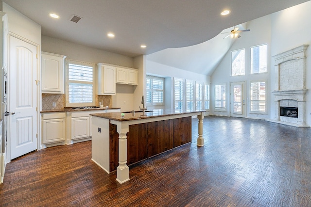 kitchen featuring ceiling fan, a wealth of natural light, white cabinetry, a kitchen island with sink, and dark hardwood / wood-style floors