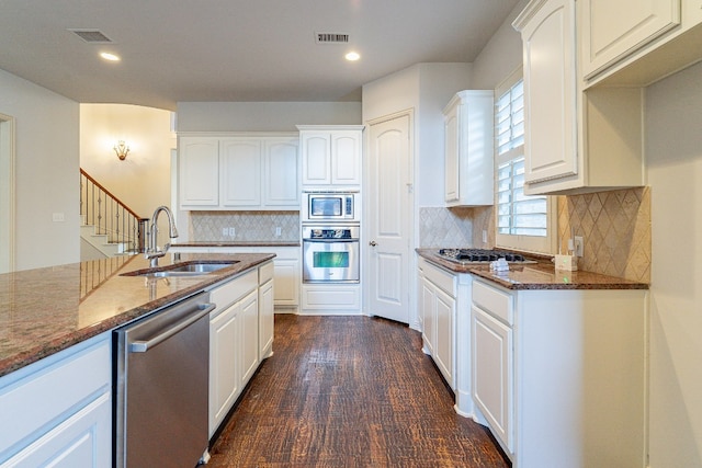 kitchen with tasteful backsplash, white cabinetry, and appliances with stainless steel finishes