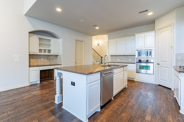 kitchen with a center island with sink, white cabinetry, dark hardwood / wood-style floors, stainless steel appliances, and sink