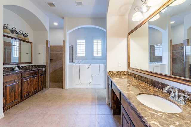 bathroom featuring tile floors, vanity, and plus walk in shower