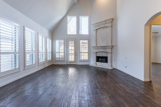 unfurnished living room featuring high vaulted ceiling and dark hardwood / wood-style floors