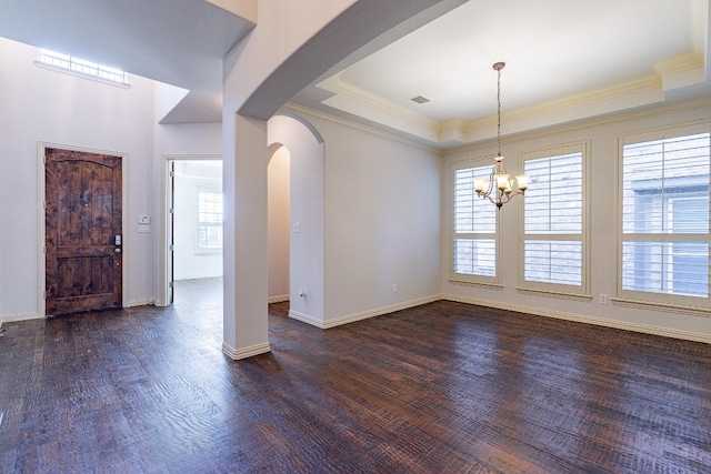 entryway featuring an inviting chandelier, dark hardwood / wood-style flooring, a healthy amount of sunlight, and a tray ceiling