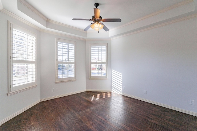 spare room featuring dark hardwood / wood-style flooring, ceiling fan, a raised ceiling, and ornamental molding