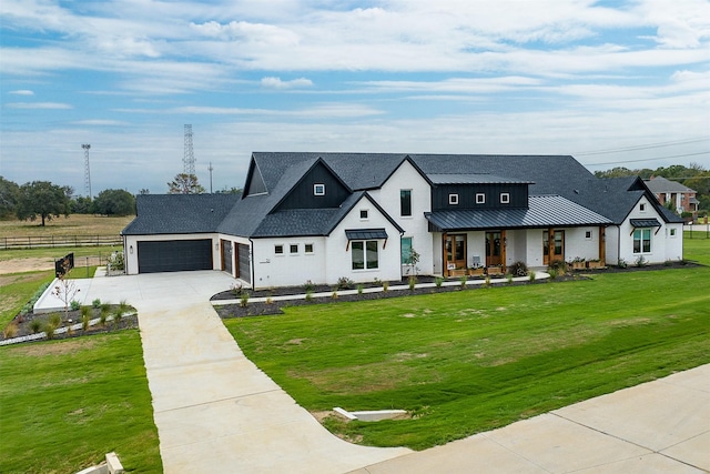 modern farmhouse featuring a garage and a front lawn