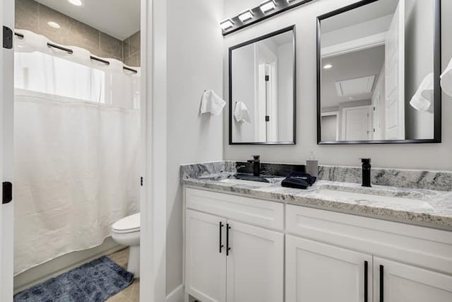 bathroom featuring tile floors, toilet, and dual bowl vanity