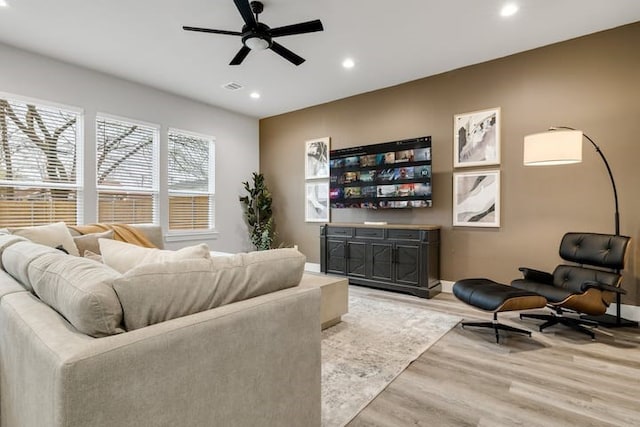 living room with ceiling fan and light hardwood / wood-style flooring