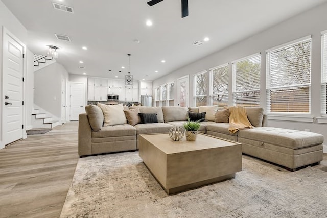 living room featuring ceiling fan and light hardwood / wood-style flooring