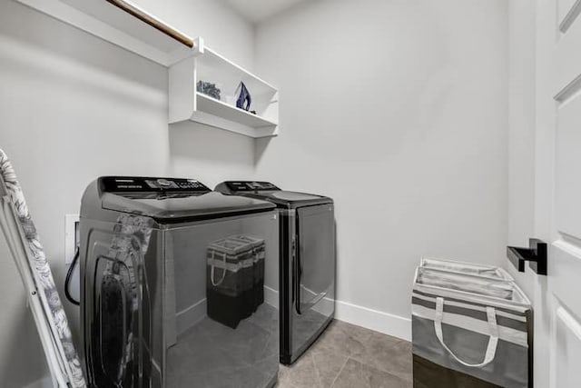 clothes washing area with tile floors and washer and dryer