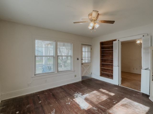 unfurnished bedroom with ceiling fan and dark wood-type flooring