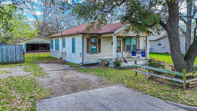 bungalow-style home with an outbuilding, a front yard, a porch, and a garage