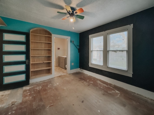 empty room featuring ceiling fan and a textured ceiling