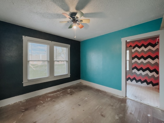 unfurnished room with wood-type flooring, ceiling fan, and a textured ceiling