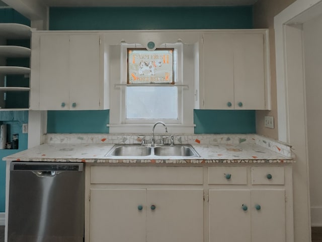 kitchen featuring dishwasher, sink, and white cabinetry