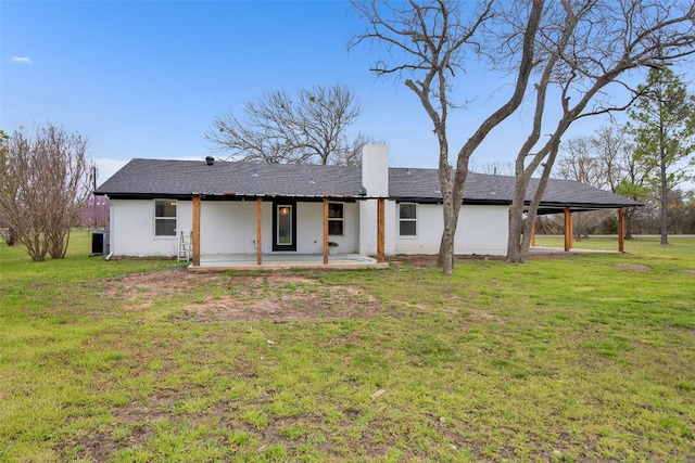 rear view of house with a lawn and a patio