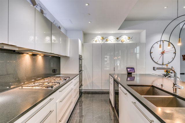 kitchen featuring white cabinets, sink, backsplash, and appliances with stainless steel finishes