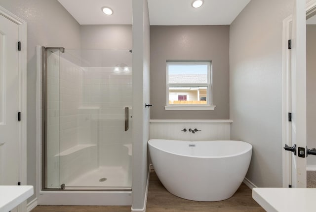 bathroom featuring separate shower and tub and hardwood / wood-style floors