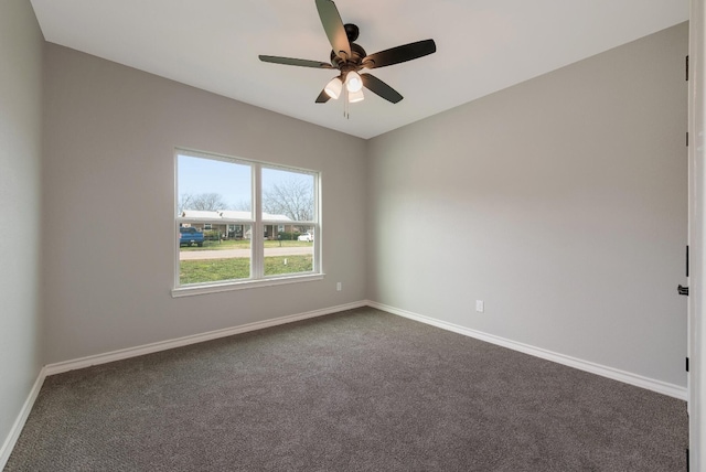 empty room featuring ceiling fan and dark carpet