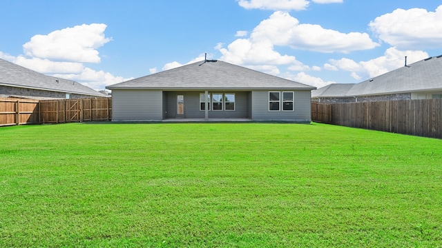 back of property with a yard and a patio