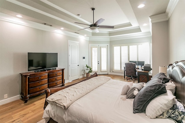 bedroom featuring ceiling fan, french doors, a raised ceiling, light hardwood / wood-style floors, and ornamental molding