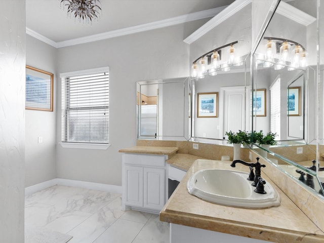 bathroom with marble finish floor, crown molding, vanity, and baseboards