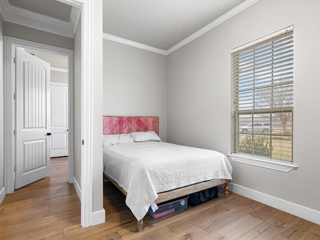 bedroom featuring baseboards, ornamental molding, and wood finished floors