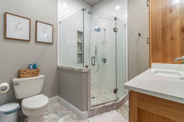 bathroom featuring vanity, a shower with shower door, and toilet