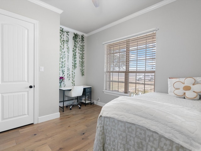 bedroom featuring a ceiling fan, crown molding, light wood-style flooring, and baseboards