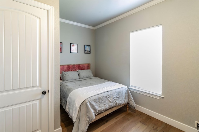 bedroom with hardwood / wood-style flooring and ornamental molding