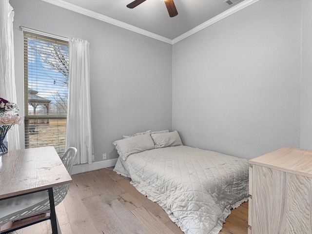 bedroom featuring visible vents, baseboards, ceiling fan, crown molding, and light wood-style floors