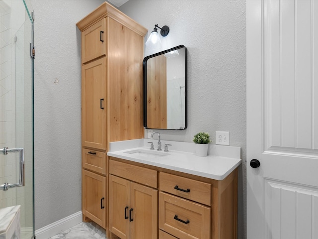 full bath with marble finish floor, a textured wall, a tile shower, and vanity