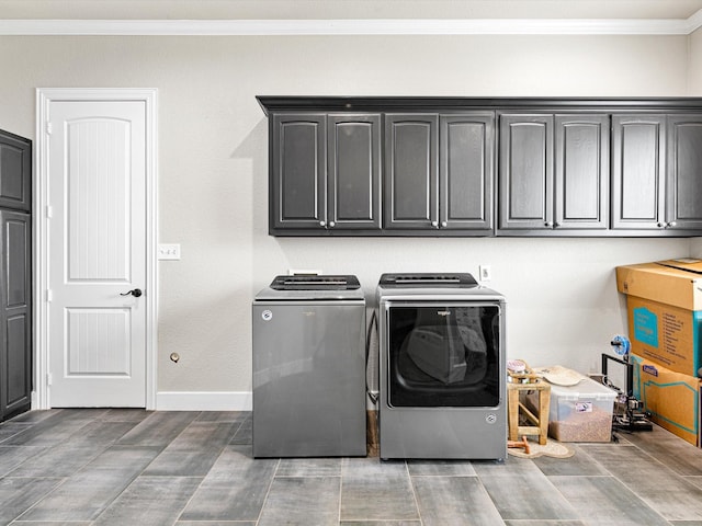 laundry area featuring ornamental molding, washing machine and clothes dryer, cabinet space, and baseboards